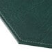 A close-up of a green faux leather surface with stitching.