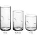 A group of Acopa clear beverage glasses with a thumbprint design on the bottom.
