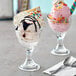 Two Acopa dessert dishes with ice cream sundaes topped with sprinkles and chocolate sauce.