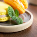 A Chef & Sommelier Geode gray stoneware plate with two macarons and mint leaves.