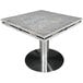 A Kashmir White granite table top with drop leaf edges on a metal base.
