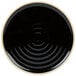 A black stoneware plate with a white spiral design in the center.