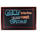 A mahogany-framed black chalk board on a counter with colorful writing for dinner specials.
