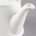 A close-up of a white Villeroy & Boch teapot with a lid.