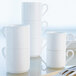 A close-up of a stack of white Villeroy & Boch Stella Hotel bone porcelain coffee cups.