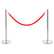 A Lancaster Table & Seating silver rope-style crowd control stanchion with red rope wrapped around it.