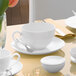 A white Villeroy & Boch saucer with a white teacup on a table.
