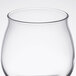 A close-up of a clear Reserve by Libbey Kentucky Bourbon Tasting Glass with a small amount of liquid in it.