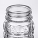 A close up of a clear glass Tablecraft Nostalgia salt and pepper shaker with a stainless steel top.