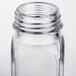 A close up of a clear glass square salt and pepper shaker with a lid.