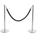 A Lancaster Table & Seating silver crowd control stanchion with black rope on a metal pole.