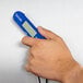 A hand holding a blue Taylor digital probe thermometer.