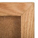 An Aarco natural oak wood frame with cork board inside.