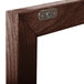 A close-up of the walnut wood frame with a metal latch.