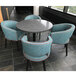 A grey Art Marble Furniture round table top on a table with blue chairs around it.