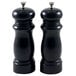 Two black pepper mills with black lids.