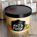 A close-up of a black Choice Medley paper soup container with a black lid and label.