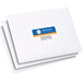 A stack of white envelopes with Avery Print-to-the-Edge Address Labels with blue and orange text.