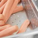 A Choice stainless steel steam table pan filled with hot dogs.