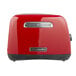A red KitchenAid toaster with black handles.