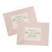 Two pink envelopes with Avery rectangular pearlized ivory labels with black writing.