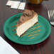 A slice of cheesecake on a Carlisle meadow green melamine pie plate.