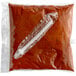 A plastic bag of Carnival King chili sauce with a white tube inside.