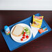 A Cambro horizon blue dietary tray with a sandwich, chips, and a drink on it.