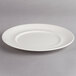 A white Villeroy & Boch porcelain plate with a rim on a gray surface.