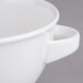 A close-up of a Villeroy & Boch white porcelain soup cup with a handle.