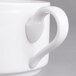 A close-up of a white Villeroy & Boch porcelain soup cup with a handle.