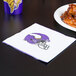 A Minnesota Vikings 2-ply luncheon napkin with a football helmet logo next to a plate of chicken wings.