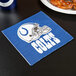 A blue and white Creative Converting Indianapolis Colts luncheon napkin with a helmet on it next to a plate of food.