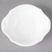 A white Villeroy & Boch porcelain bowl with a handle on a gray surface.