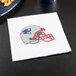 A Creative Converting New England Patriots luncheon napkin with a helmet on it on a counter.
