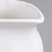 A close up of a white Villeroy & Boch porcelain creamer with a small bowl on top.