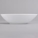 A Villeroy & Boch white porcelain oval deep bowl on a gray surface.
