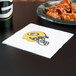 A green Bay Packers luncheon napkin on a table next to a plate of chicken wings.