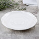 A white Villeroy & Boch porcelain saucer with a swirl pattern.