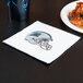 A napkin with a Carolina Panthers logo on it next to a plate of chicken wings.