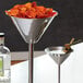 An American Metalcraft stainless steel martini glass server on a table in a cocktail bar.