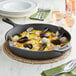 A Choice pre-seasoned cast iron skillet with seafood rice and mussels.
