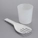 A white plastic measuring cup and spoon next to a white plastic cup.