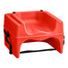 A red plastic Lancaster Table & Seating booster seat with black straps.