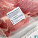 A roll of 2-inch by 2-inch safe food handling instruction labels in a dispenser carton, applied to packaged raw meat.