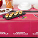 A Creative Converting Arizona Cardinals plastic table cover on a table with food on it.