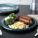 A Creative Converting Philadelphia Eagles paper dinner plate with broccoli, sausage, and macaroni on it.