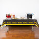 A Pittsburgh Steelers plastic table cover on a table with food.