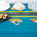 A Jacksonville Jaguars plastic table cover on a table with plates and cups.