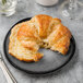 A croissant on a Libbey Pebblebrook porcelain plate with a fork and knife.